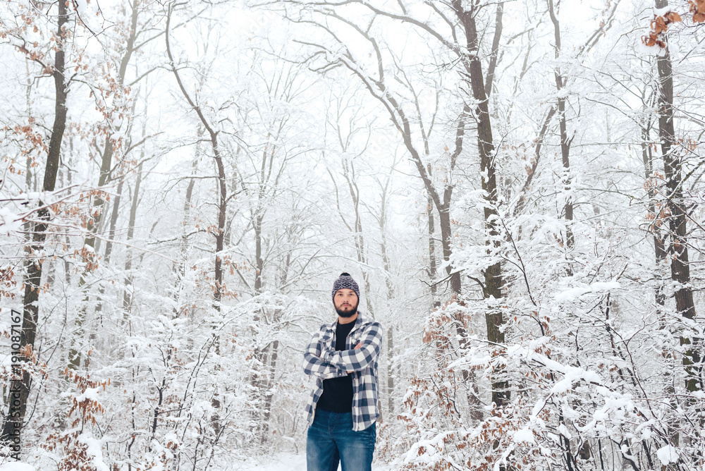 man in plaid shirt in the woods in winter man in plaid shirt in the woods in winter