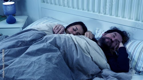 Couple sleeping hugged at night in bed peaceful closeup