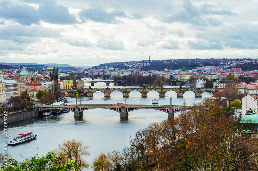 Scenic view of bridges on the Vltava river and of the historical center of Prague: buildings and landmarks of old town with red rooftops. Concept of Europe travel, sightseeing and tourism.