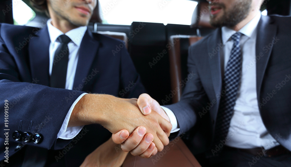 handshake of business partners sitting in the car handshake of business partners sitting in the car
