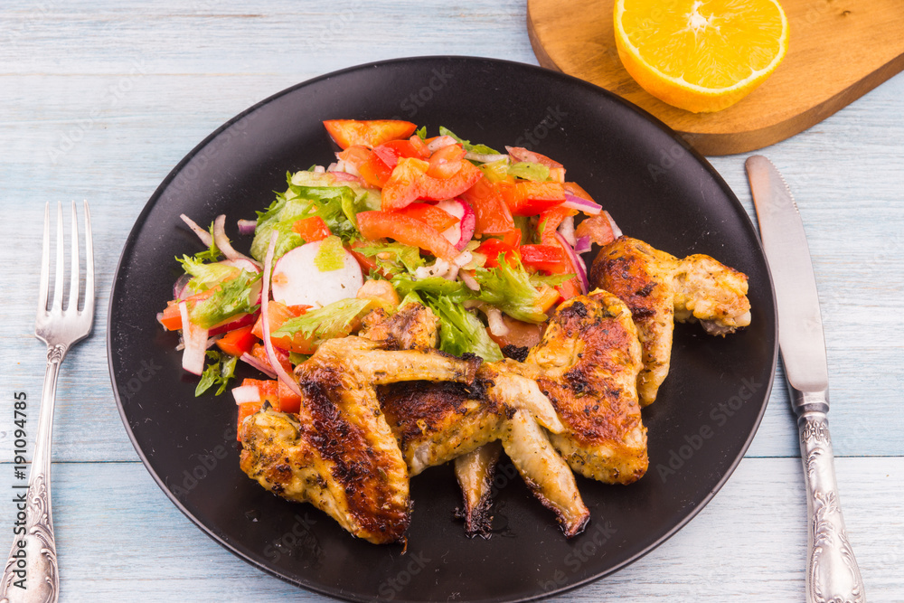 Fried chicken wings on rustic with salad close-up, top view Fried chicken wings on rustic with salad close-up, top view