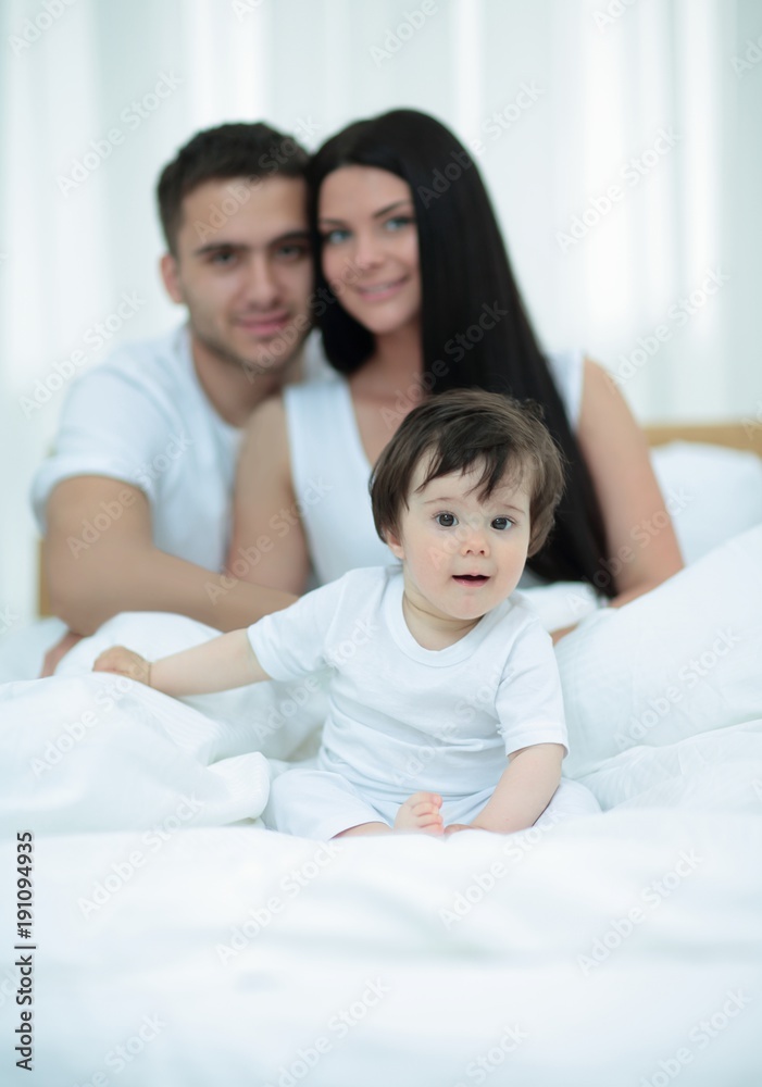 Portrait of a joyful family sitting on the bed at home Portrait of a joyful family sitting on the bed at home
