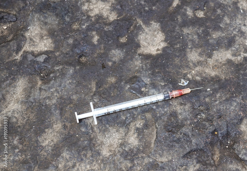 substance abuse, addiction and drug use concept - close up of used syringes on ground