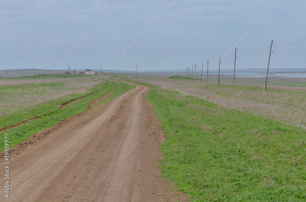 unpaved country road in spring steppe near lake Manych-Gudilo Manychskiy, Republic of Kalmykia, Russia