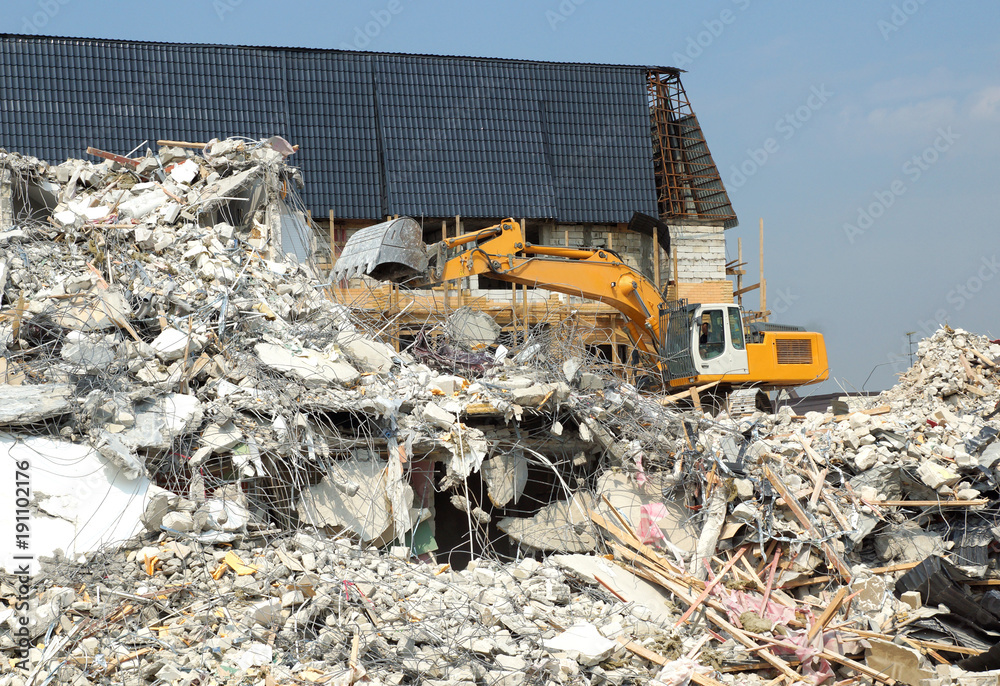 Dismantling of concrete structures, excavators break down old buildings