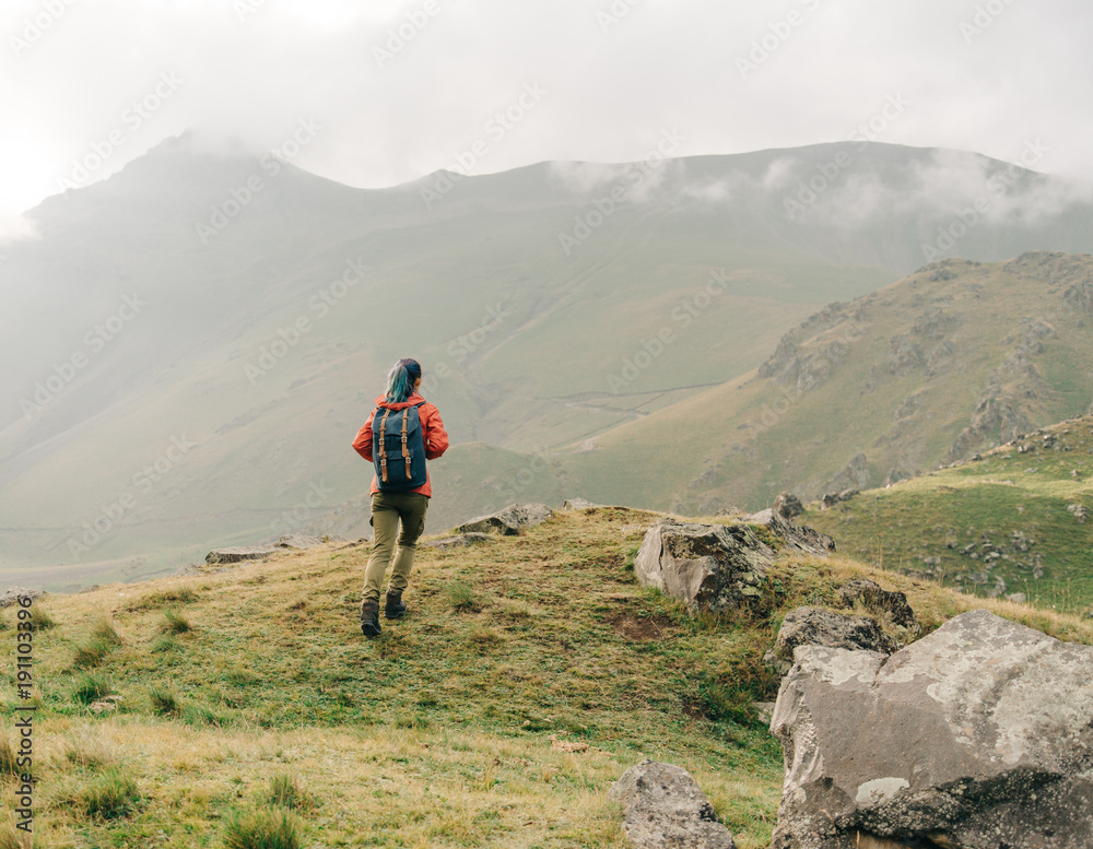 Hiker woman walking in the mountains. Hiker woman walking in the mountains.