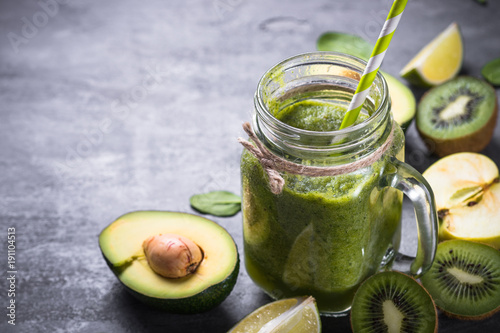 Healthy green smoothie in mason jar and ingredients. 