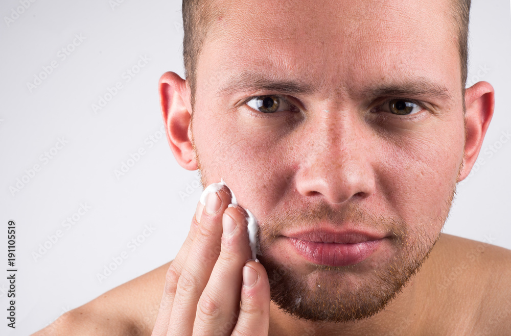 Obraz premium Close-up of young man applying shaving cream