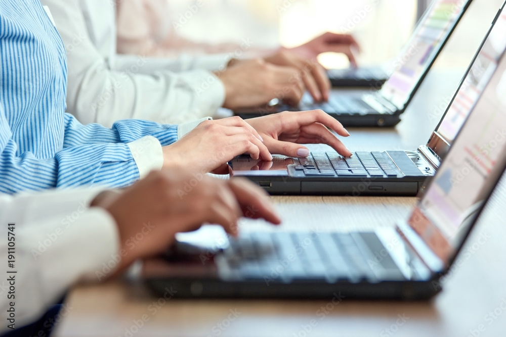 Female hands typing on laptop. Line of office workers hands typing on laptops computers. Female hands typing on laptop. Line of office workers hands typing on laptops computers.