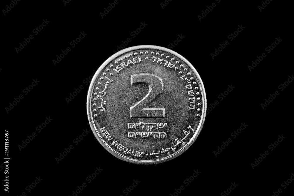 A macro image of an Israeli two shekel coin isolated on a black background A macro image of an Israeli two shekel coin isolated on a black background
