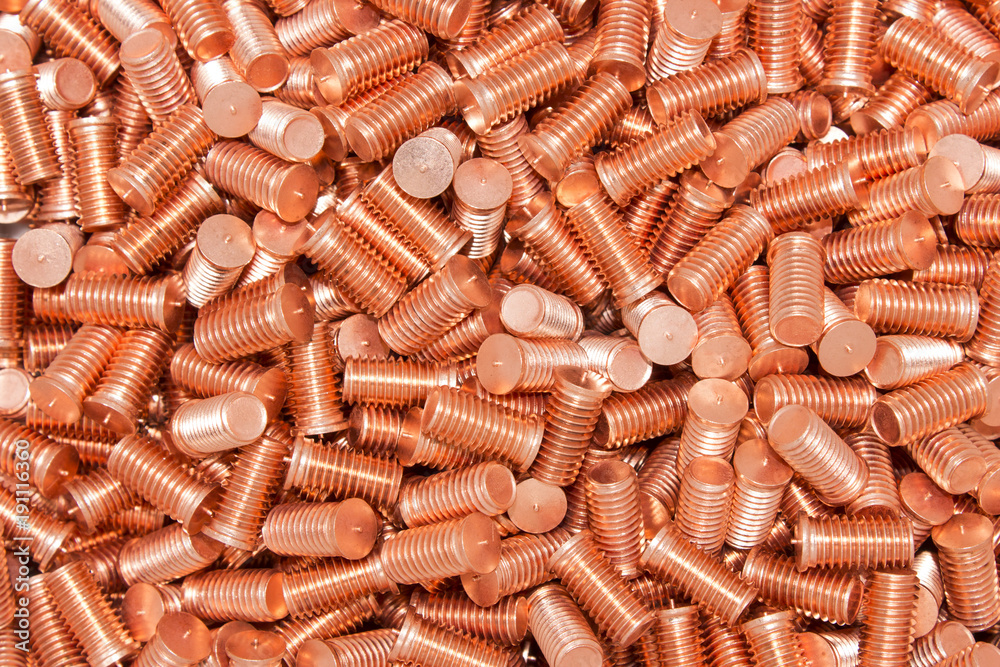 Pile of threaded copper metal screw bolts Pile of threaded copper metal screw bolts