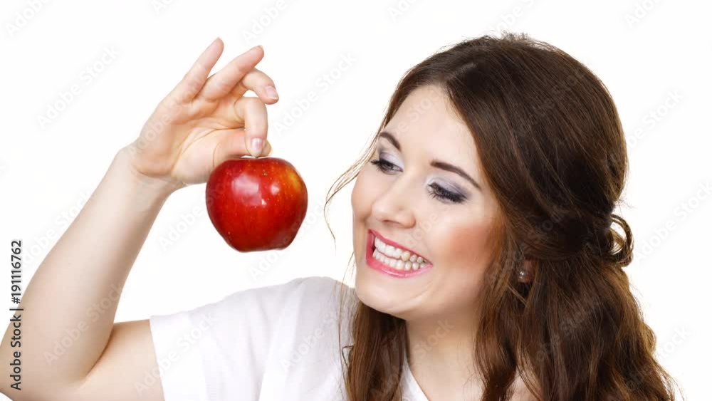 Woman toothy smile brunette female holding red apple fruit in hand close to face, isolated on white. Healthy eating, vegetarian food, diet concept. Woman toothy smile brunette female holding red apple fruit in hand close to face, isolated on white. Healthy eating, vegetarian food, diet concept.