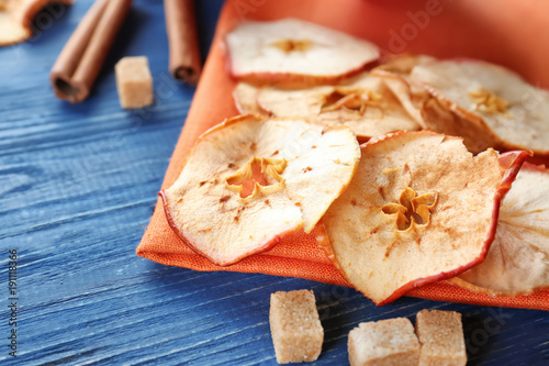 Tasty apple chips on wooden table