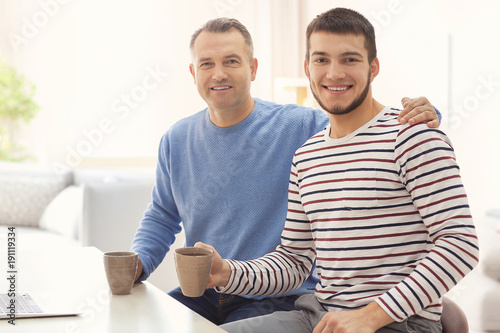 Mature man spending time with his son at home