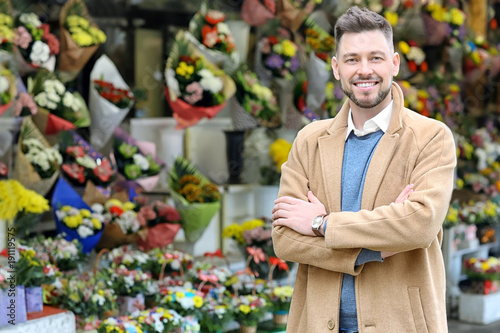 Business owner near his store with flowers
