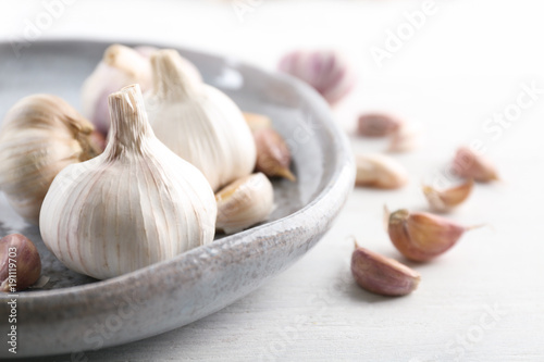 Plate with fresh garlic on table