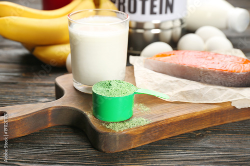 Scoop with hemp protein powder and products on table