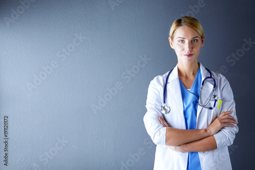 Portrait of young woman doctor with white coat standing in hospital. photo
