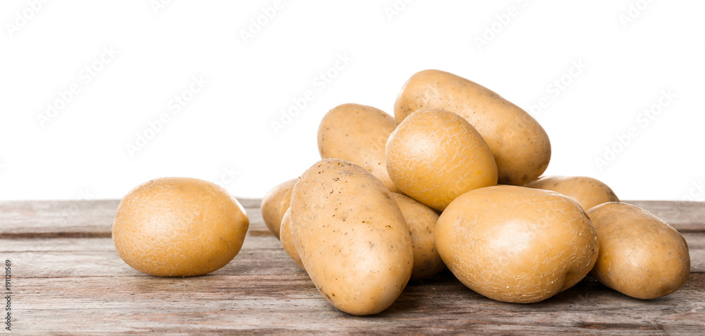Fresh raw potatoes on wooden table against white background Fresh raw potatoes on wooden table against white background
