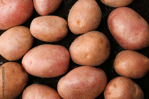 Fresh raw potatoes on ground  top view