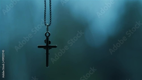 Christian crucifix pendant swinging on chain.