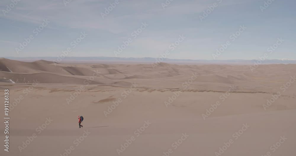Wide Shot of Woman Backpacking in Sand Dunes Wide Shot of Woman Backpacking in Sand Dunes