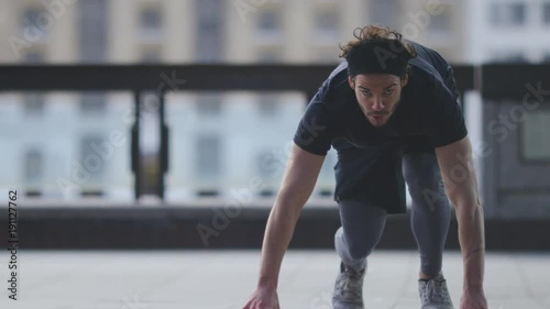 Young man practising his sprint starts in the city, in slow motion