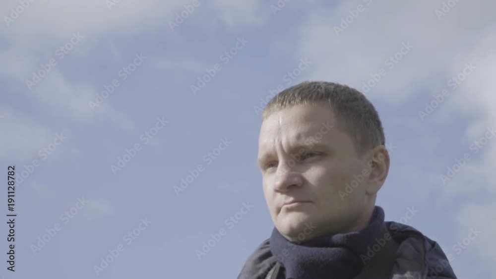 Young man photographer looking around slow motion. Sky clouds background Young man photographer looking around slow motion. Sky clouds background