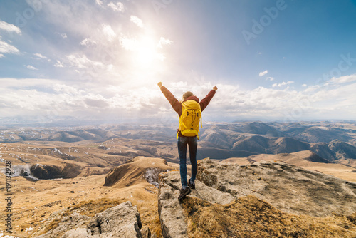 woman tourist standing against a background of high mountains on a sunny day photo