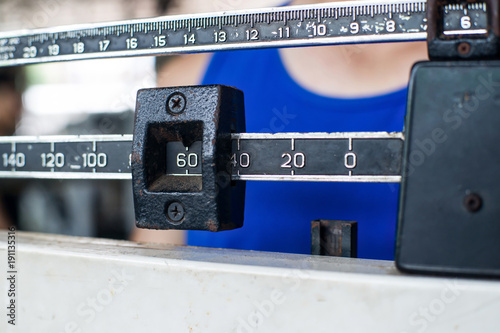 Tableau sur toile Sport man weighing himself on balance weight scale at the gym