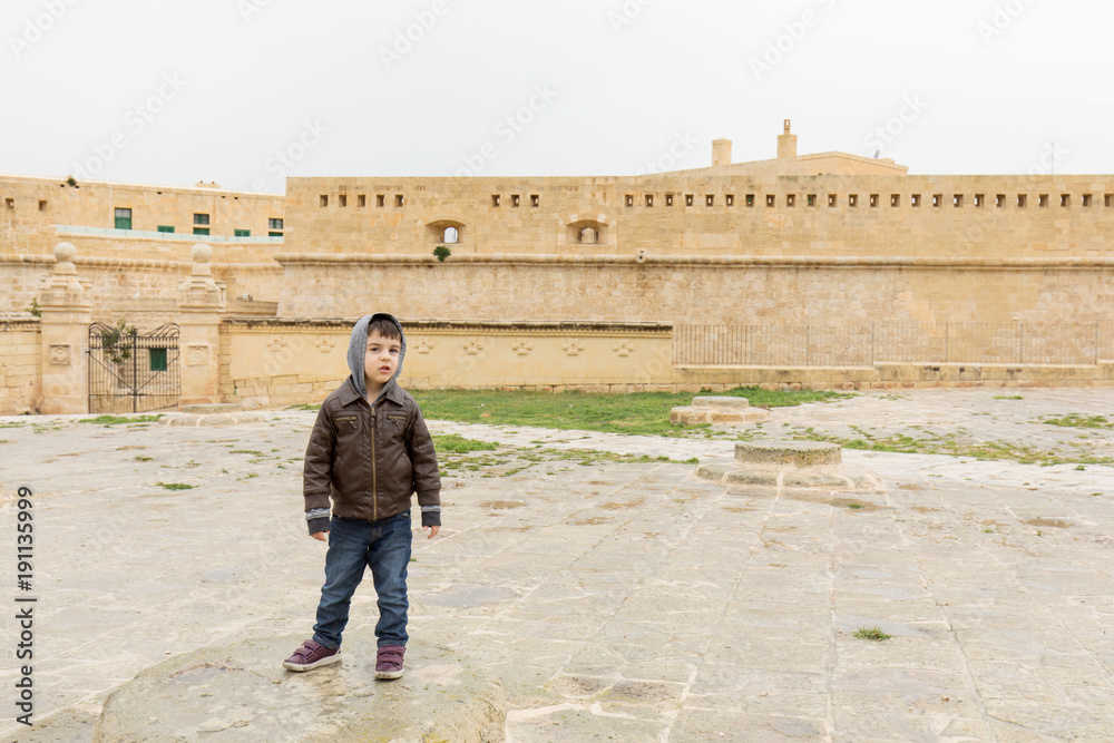 Young boy playing in front of Saint Elmo fort, Valletta, Malta