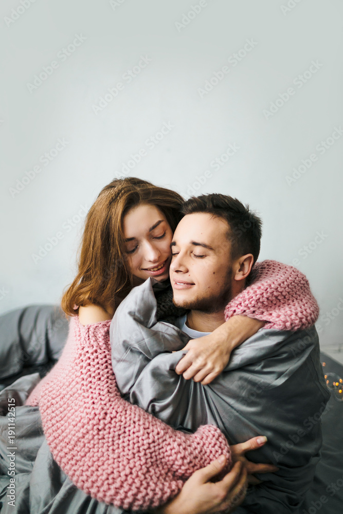 Cute Young Woman Embracing Her Boyfriend. Young couple hugging at home. Artwork. Soft focus