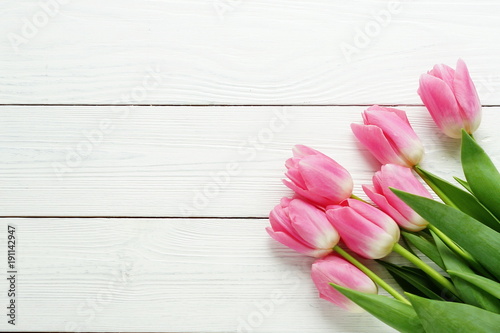 Fototapeta Naklejka Na Ścianę i Meble -  a bouquet of pink tulips on a white wooden background. top view. copy space. Holiday concept.