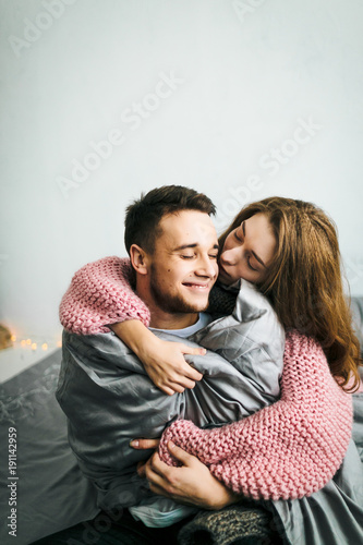 Cute Young Woman Embracing and Kiss Her Boyfriend. A couple having fun in the bed. Artwork. Soft focus