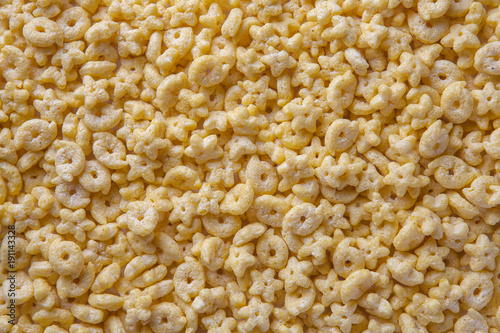 Bild auf Leinwand Background of cornflakes in the form of rings and stars, closeup.