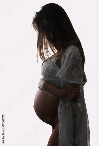 Beautiful pregnant woman touching her belly on a white background 