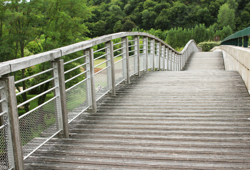 undulating wooden and metal walkway over river