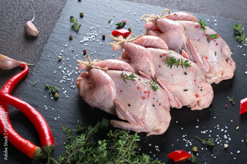 Fresh  raw meat quails ready for cooking on the  slate board