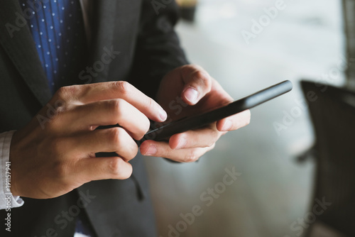 businessman holding smartphone & using app. man texting message outdoors. social network communication, wireless connection, lifestyle concept