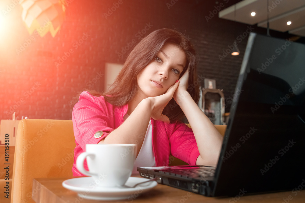 Fototapeta premium Young, beautiful girl, businesswoman, sitting in cafe and working on laptop. business lunch, cup of coffee, successful business woman.