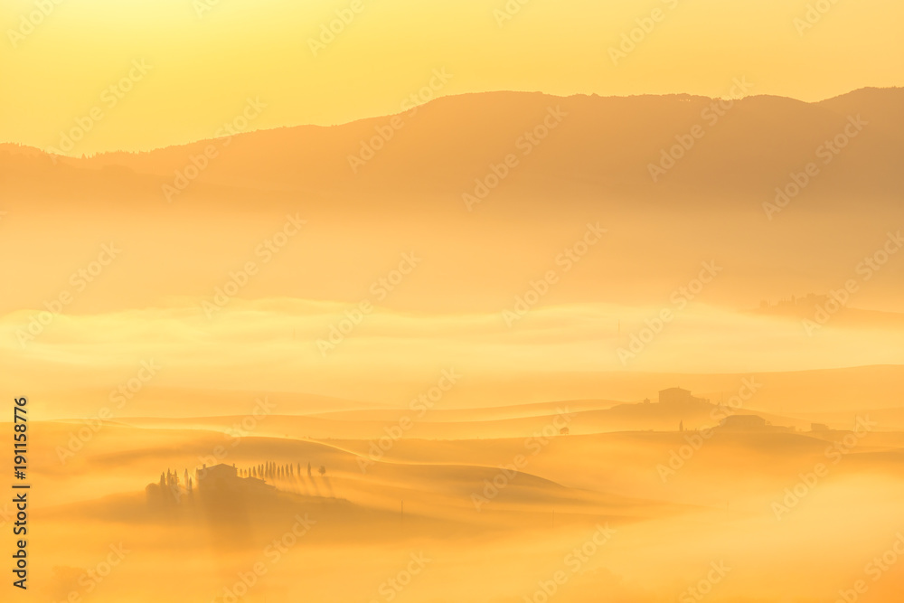 Enchanting golden foggy sunrise in Tuscany, Italy