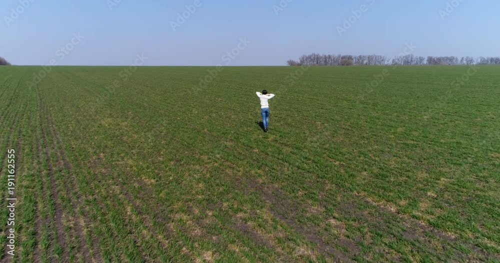 Energetic woman running across spring field Energetic woman running across spring field