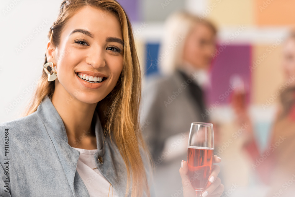 cheerful asian girl celebrating with glass of champagne in modern office cheerful asian girl celebrating with glass of champagne in modern office