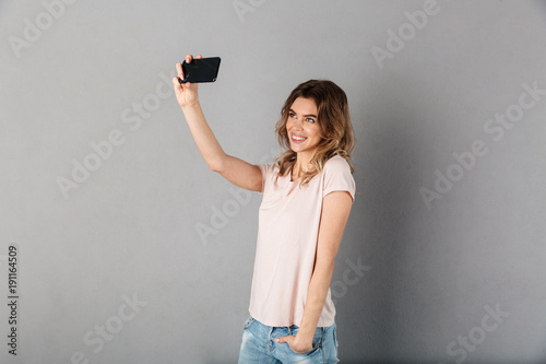 Happy woman in t-shirt making selfie on smartphone