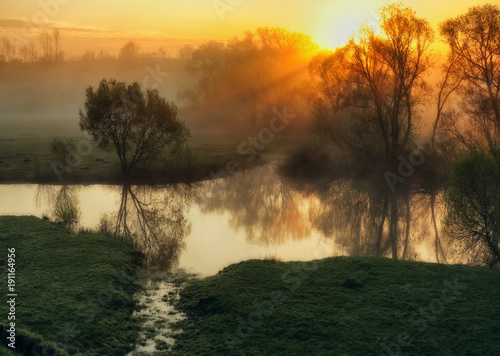 spring morning. a picturesque foggy dawn by the river. Sun rays © sergnester