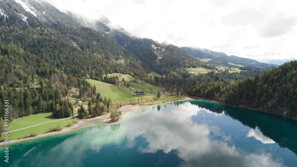 Aerial: flying over Hintersteiner Mountain lake with clear water in Austria 