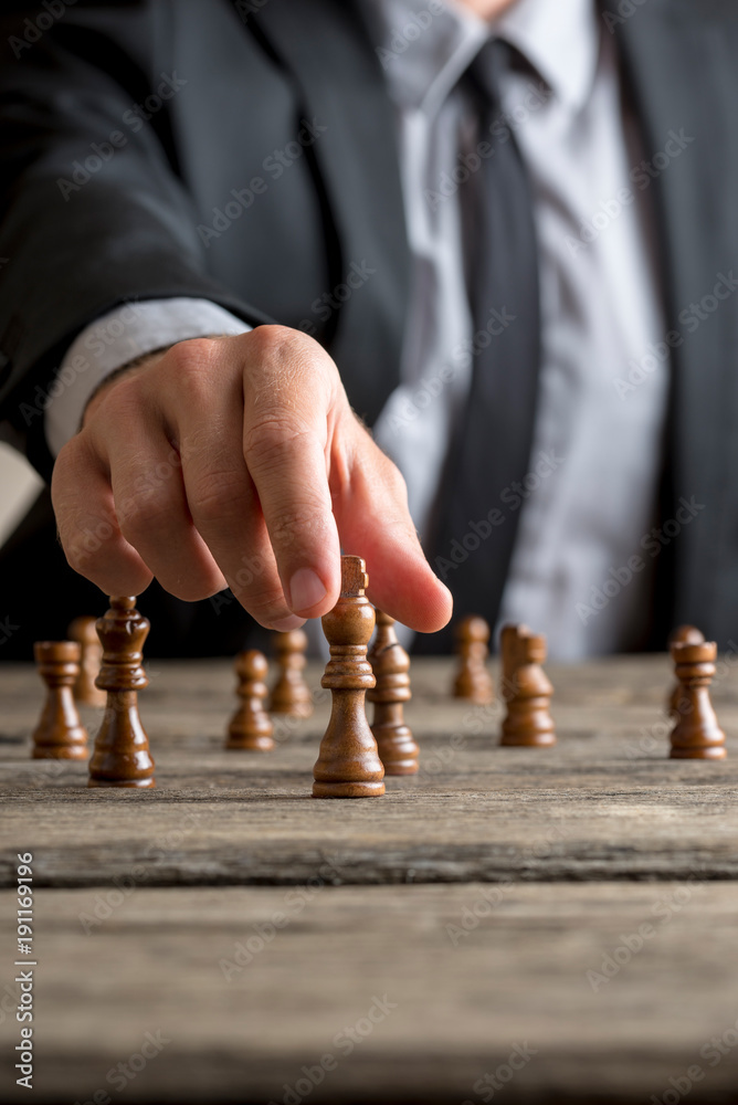 Businessman playing a game of chess on an old wooden table - obrazy, fototapety, plakaty 