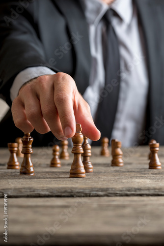 Businessman playing a game of chess on an old wooden table