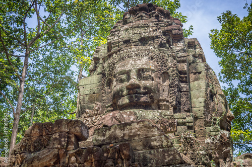 Giant stone face on an ancient temple in Angkor Wat, Siem Rep, Cambodia photo