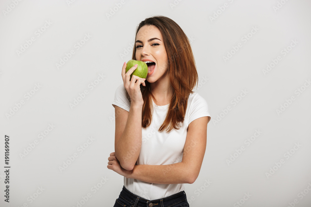 Portrait of a cheerful young woman eating green apple Portrait of a cheerful young woman eating green apple